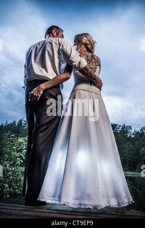 Young couple standing by the lake in the park Stock Photo