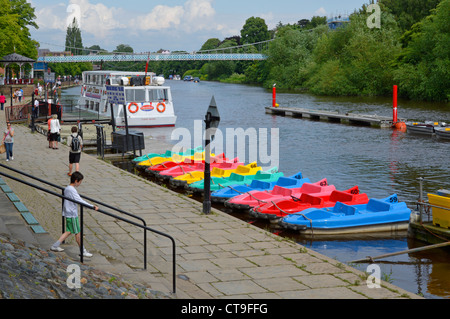 Summer view of white sightseeing tour boat on the River Dee at Chester colourful peddle boats at riverside moorings suspension bridge Cheshire England Stock Photo