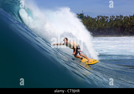 Australian surfer riding a wave in south Nias Island, Sumatra, Indonesia. Stock Photo