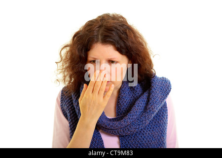 Young brown-haired woman with wool scarf sniffs the hand, isolated on white background, studio shot. Adobe RGB Stock Photo