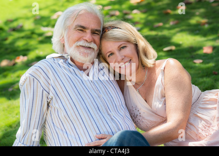 Old people and romance, elderly husband and wife in love, lying on grass in park Stock Photo