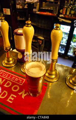 A pint of ale, beer on the bar at the The Grenadier pub, Wilton Row, Belgravia, London, at dusk, pub table drinks glasses Stock Photo