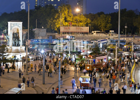 People and tram at Taksin square in the evening, Cumhuriyet Abidesi monument, Istanbul, Turkey, Europe Stock Photo