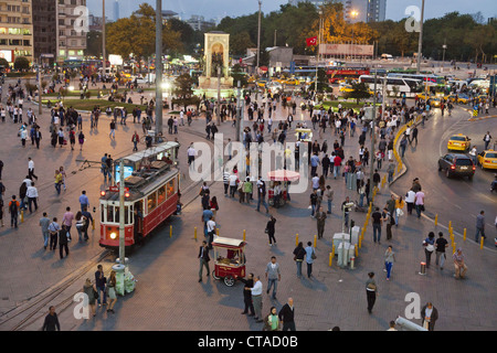 People and tram at Taksin square in the evening, Cumhuriyet Abidesi monument, Istanbul, Turkey, Europe Stock Photo