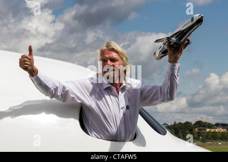 Richard Branson at Farnborough International Airshow 2012 posing inside mock-up of  'Spaceship 2' holding model of 'Launcher 1' Stock Photo