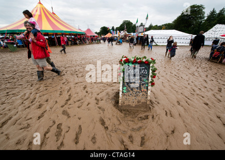 visitors to the Larmer Tree Festival in Dorset brave the muddy conditions after bad weather sweeps across the UK