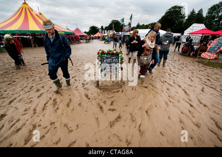 visitors to the Larmer Tree Festival in Dorset brave the muddy conditions after bad weather sweeps across the UK