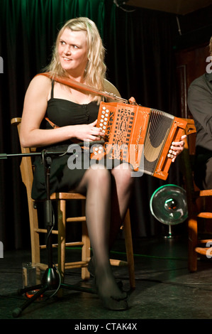 Lorraine playing the accordian with 'Púca' a traditional Irish music band group playing at the Arlington Hotel, Dublin. Stock Photo