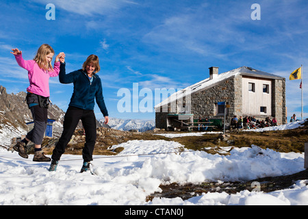 A woman helping a girl balance on a slackline at the Sewenhut, SAC Swiss Alpine-Club, Swiss Alps, Kanton Uri, Switzerland Stock Photo