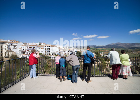 People on a vantage point admiring Old Town of Ronda on a rock and landscapes of Andalusia region in Spain. Stock Photo