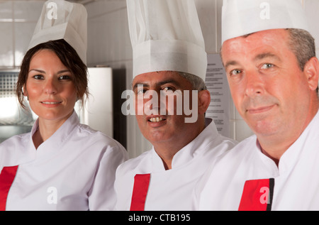 group of young beautiful professional chefs portrait in industrial kitchen Stock Photo