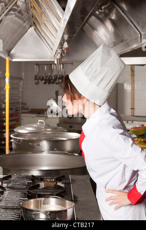 female chef at kitchen taste soup Stock Photo