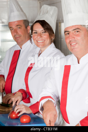 group of young beautiful professional chefs portrait in industrial kitchen Stock Photo