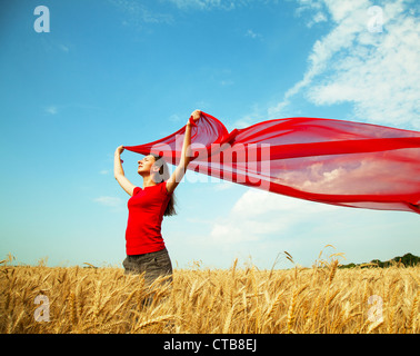 Teen girl at a wheat field with red fabric Stock Photo