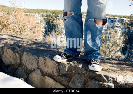 View of torn blue jeans of a young man on a road trip through Arizona Stock Photo