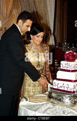 East Indian Sikh groom bride cutting wedding cake marriage celebration reception Stock Photo