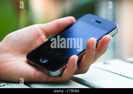 This is an image of an Iphone 4 in a woman's hand Stock Photo
