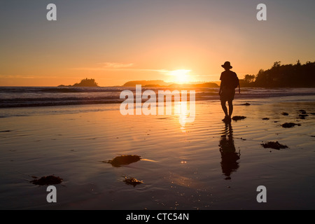 Woman watching sunset on Chesterman Beach, Pacific Rim national park reserve, Vancouver island, Canada Stock Photo