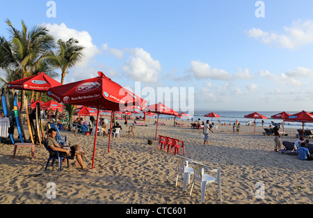 Tourists relaxing on Legian Beach near Kuta in Bali. Stock Photo