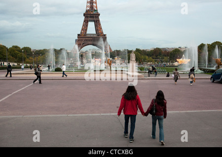 A romantic scene when a couple holds hands near the Eiffel Tower in Paris, France. Stock Photo