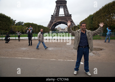 tourists pose to photos in the park near the eiffel tower in paris ctcya6