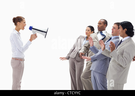 Woman yelling at business people through a megaphone Stock Photo