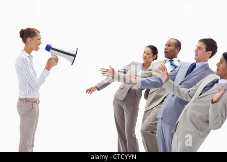 Woman yelling at people dressed in suits through a megaphone Stock Photo