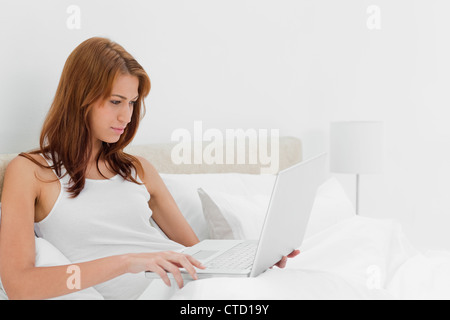Attractive redheaded woman using a laptop Stock Photo