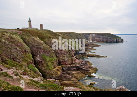 Cliff by the coast over the sea with lighthouse Stock Photo