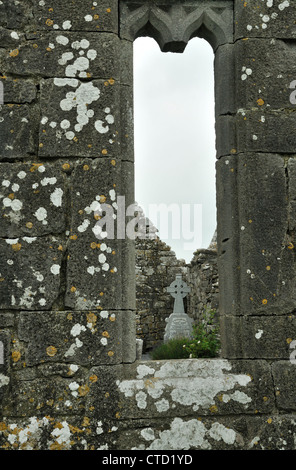 Memorial Cross viewed through window frame of the Old Church, Ruan, Co. Clare, Ireland Stock Photo