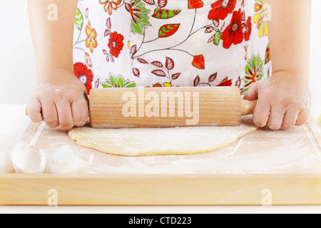 Details of woman's hands rolling dough using rolling pin Stock Photo