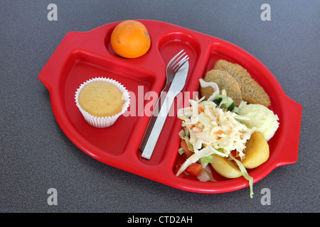 Healthy school lunch dinner served on preformed red plastic tray, salad bean burger, muffin, orange Stock Photo