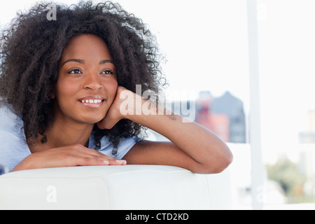 woman smiling while lying on her sofa Stock Photo