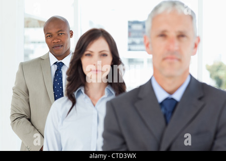 Young and serious businessman following two members of his team Stock Photo