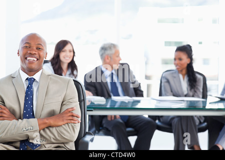 Young executive crossing his arms while laughing in front of the camera ...