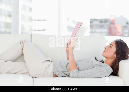 Brunette lying on her sofa Stock Photo