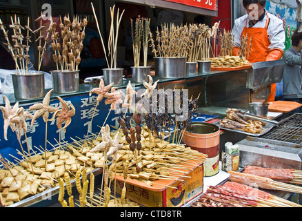 Fried insects, bugs, scorpions, starfishes on sticks at Wangfujing market street - Beijing, China Stock Photo