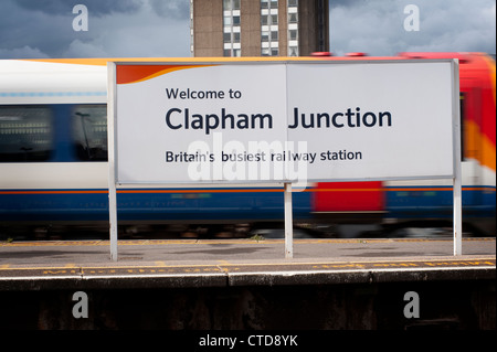 Welcome sign on the platform of Clapham Junction with train blurring past in the background, England. Stock Photo