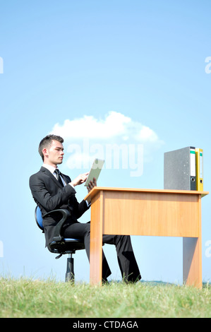 Business man at desk in nature Stock Photo