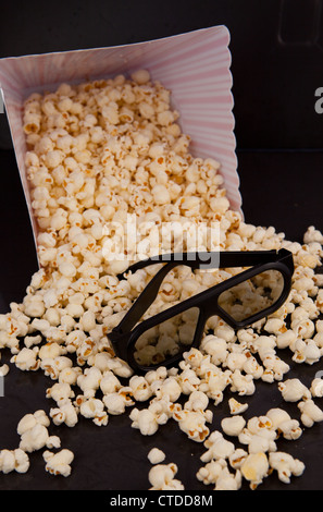 3D glasses on falling pop corn out of a box Stock Photo