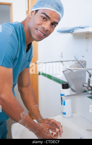 Happy male surgeon washing his hands with soap Stock Photo