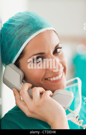 Female surgeon smiling on the phone in a hallway Stock Photo