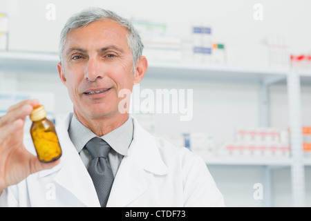 Pharmacist holding a bottle full of pills with one hand Stock Photo