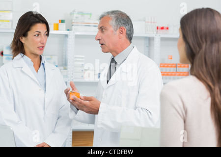 Pharmacist talking to a colleague in front of a patient Stock Photo