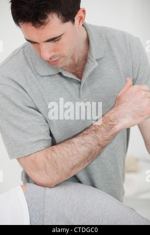 Physiotherapist using his elbow on the hip of a woman Stock Photo