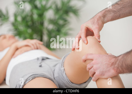 Practitioner using his fingers to massage a knee Stock Photo