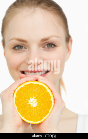 Close up of a woman squeezing an orange between her hands Stock Photo