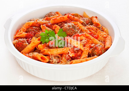 Meatballs in tomato sauce with penne pasta and parmesan cheese, baked in the oven. Stock Photo