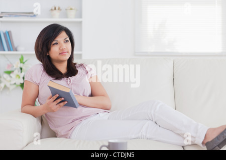 Woman relaxing while lying on a sofa Stock Photo