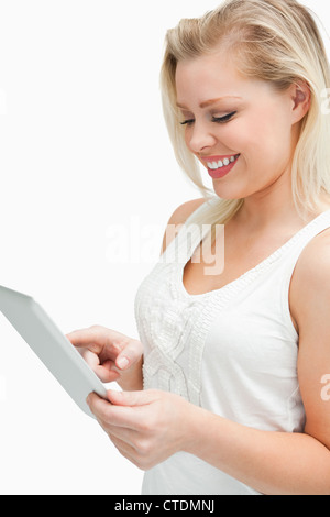 Blonde woman standing while using her tablet computer Stock Photo